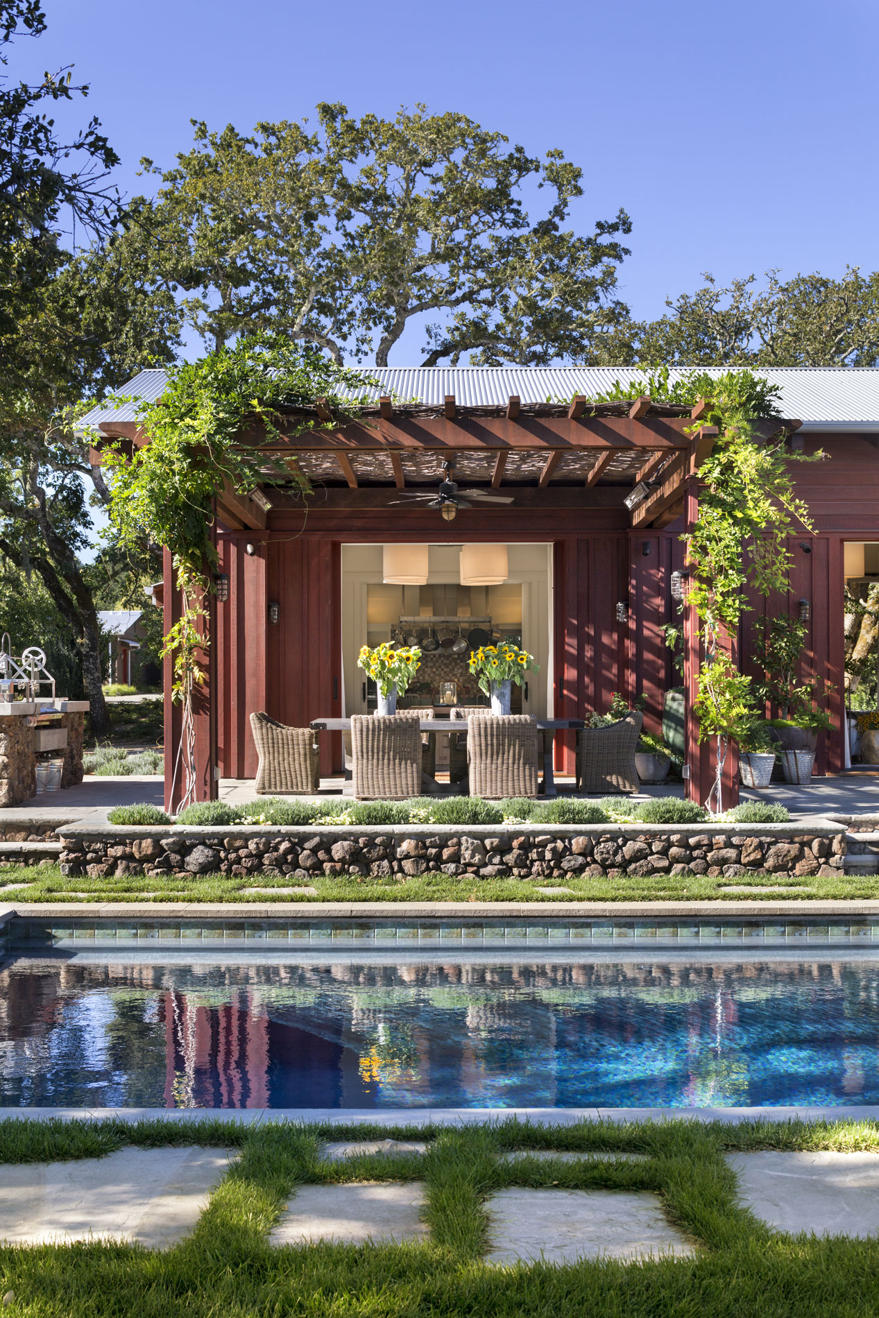 View of the wisteria-covered dining pergola across the pool. (Photo credit: Peter Aaron/OTTO for Robert A.M. Stern Architects)